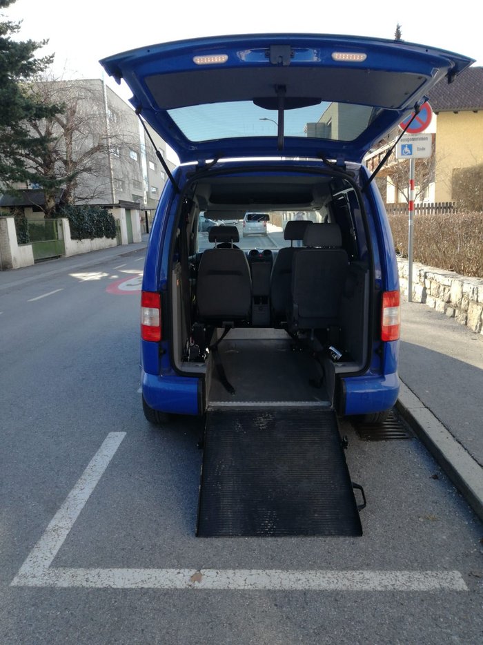 Das Bild zeigt einen blauen VW Caddy