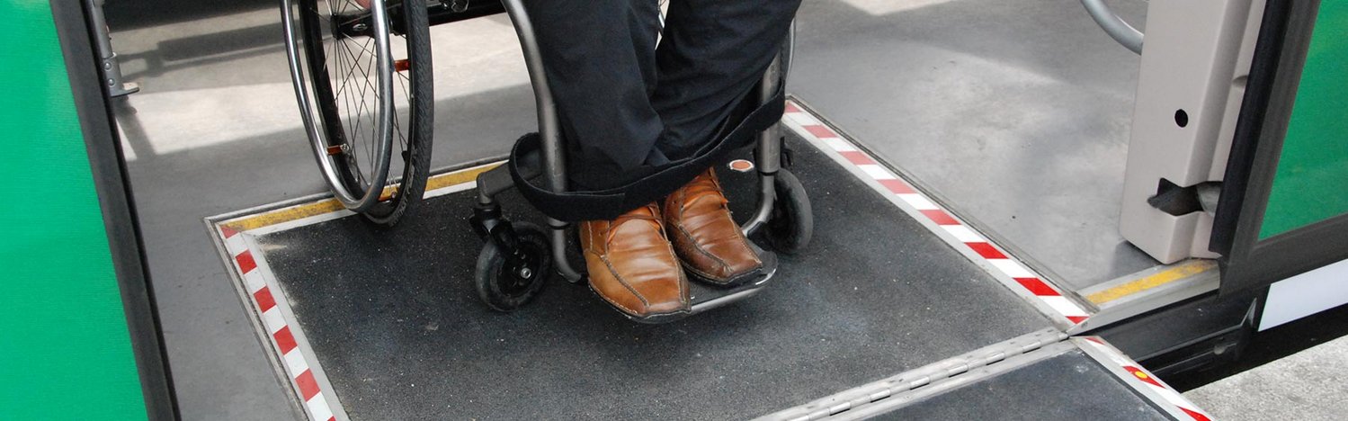 Person im Rollstuhl beim Verlassen eines öffentlichen Verkehrsmittels